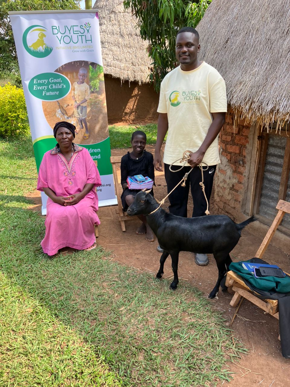 Buyesi community members with goat and banner